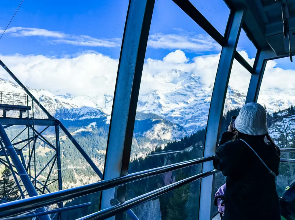 Lauterbrunnen cable car ascending mountain with Swiss Alps valley view