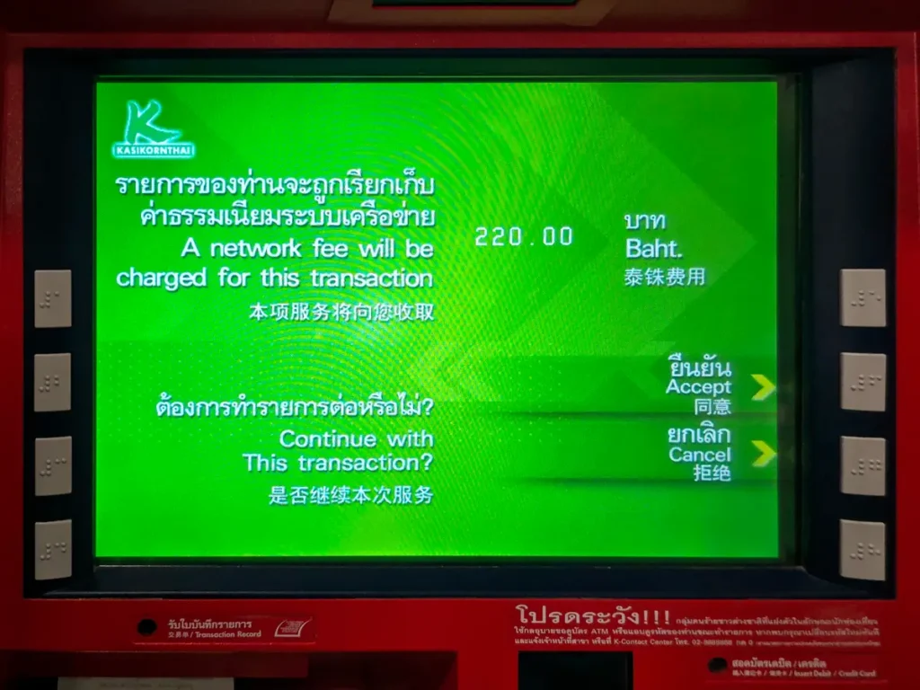 ATM screen displaying 220 baht withdrawal fee notification for foreign cards in Thailand