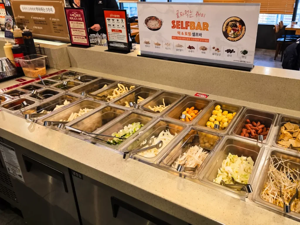 Dookki self-service bar with various rice cakes and noodles